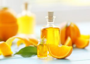 bottles of orange essential oil with orange peels