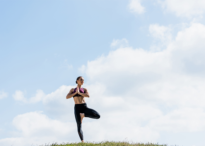 Woman doing yoga balance exercises outdoors